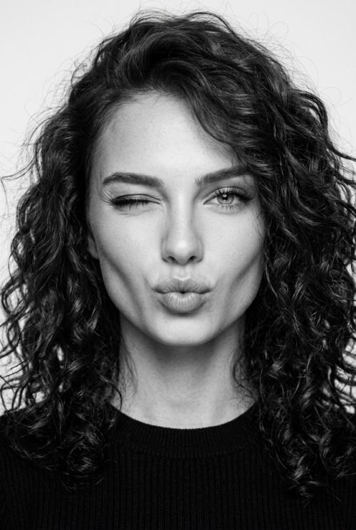 Молодая женщина с копной густых, вьющихся волос. 

